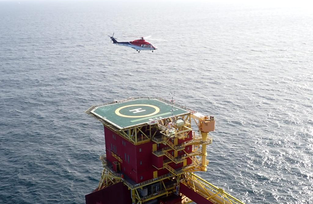 Offshore platforms are one of the most lucrative environments for rope access technicians Aerial view of an offshore platform helideck with helicopter approaching