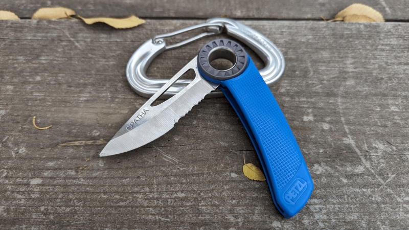 The Petzl Spatha — a purpose-built rope rescue tool, not a weapon Petzl Spatha rescue knife on a wooden surface with carabiner